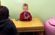 Boy at table holding ball